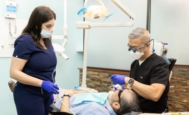 Dentist and assistant treating a patient in a clinic